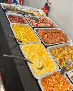 many trays of food are lined up on a table