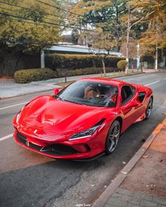 a red sports car driving down the street