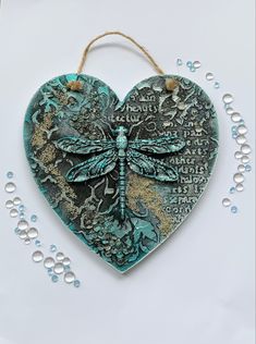 a heart shaped ornament with a dragonfly on it