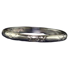 an antique silver wedding band with flowers on it