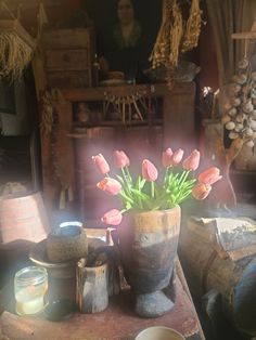 a vase filled with pink flowers sitting on top of a table next to other items