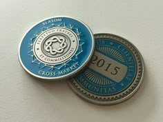 two commemorative coins sitting side by side on top of a white surface, with the word cross - massage printed on it