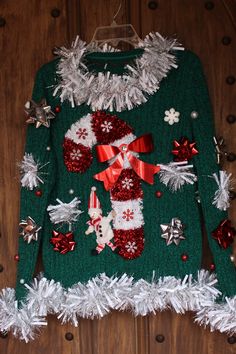 a green sweater with red and white decorations on it