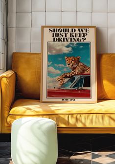 a poster on the back of a yellow couch in a room with black and white tiles