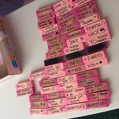 a pile of pink post it notes sitting on top of a table next to a box