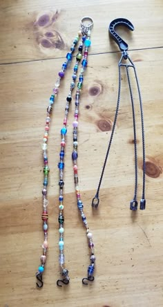 two lanyards on a wooden table with a leash attached to one end and beads hanging from the other side