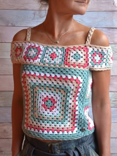 a woman wearing a crocheted top with an off the shoulder design on it