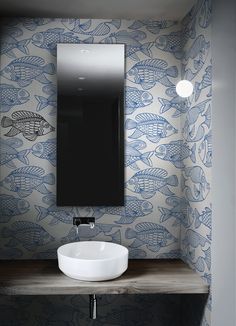 a white sink sitting under a bathroom mirror next to a wall mounted faucet