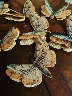 several butterflies are sitting on top of a wooden table with words written on them,