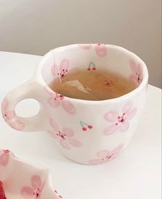 a cup of tea sitting on top of a white table