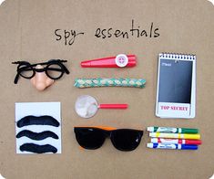 an assortment of office supplies laid out on top of a cardboard board with the words spy essentials written above them