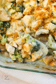 a casserole dish with broccoli, chicken and cheese in it on a white cloth