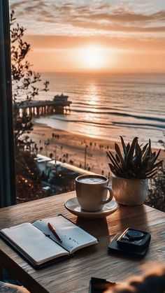 a cup of coffee sitting on top of a wooden table next to a book and calculator