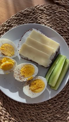 a white plate topped with hard boiled eggs and sliced cucumbers