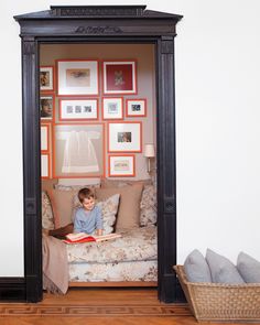 a little boy sitting on top of a couch in a living room under a mirror