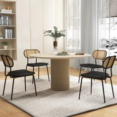 a dining room table with chairs and a rug on the floor in front of it