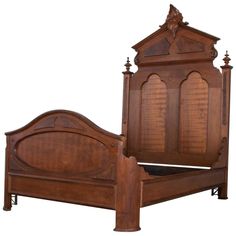 a wooden bed frame with carved details on the headboard and foot board