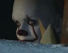 a creepy clown is staring at the camera