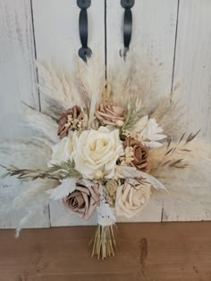 a bouquet of flowers sitting on top of a wooden table next to a white door