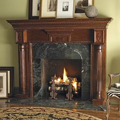 a living room with a fire place and pictures on the wall above it's mantle