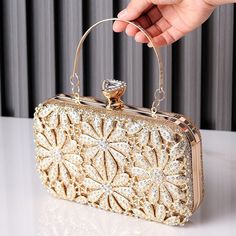 This clutch is a masterpiece of sheer elegance, boasting exquisite details that captivate the eye. From the delicate petals to the sparkling rhinestones that dance with every step, it's a symphony of beauty. Not only is it stunning, but it's also practical, lightweight, and easy to carry, ensuring you move gracefully through the night. With this clutch, beauty merges seamlessly with functionality, creating an unforgettable experience. Now available in gold and black. Flower Clutch, Rhinestone Clutch, Floral Heels, Bangle Ring, Rhinestone Flower, Bridal Belt, Bridal Bracelet, Bridal Tiara, Simple Bags