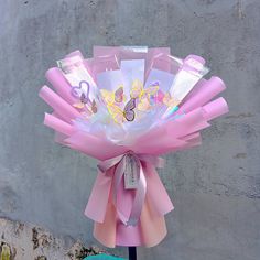 a bouquet of pink flowers on top of a blue vase with a ribbon around it