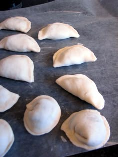 eight uncooked dumplings on a baking sheet ready to go into the oven