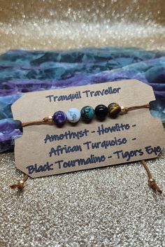 Make your travels a bit less stressful and overwhelming or conquer your fears with this fully adjustable Tranquil Traveller sliding knot adjustable bracelet Amethyst creates a sense of peace and calm during your travels and supports you in relaxing as you adjust to your new destination  Howlite supports safe travel as well as stress relief and patience  African Turquoise assists in finding your voice during travel to ask for directions or assistance during your travels Black Tourmaline a grounding and protective shield during your travels  Tigers Eye provides strength and courage during your travels Wire Wrapping Beads, Lava Stone Jewelry, Finding Your Voice, Conquer Your Fears, Jar Spells, Best Crystals, Peace And Calm, Spiritual Crystals, Wrist Candy