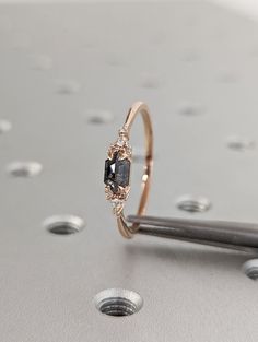 a diamond ring sitting on top of a table next to some screwdrivers and nails