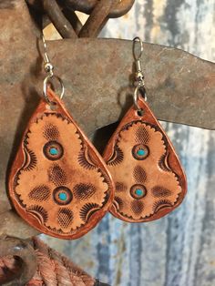 "Stamped leather earrings. Each earring is stamped by hand then hand painted with turquoise and bronze accents. This set is bold as well as lightweight. Leather piece approx: 2\" x 1.25\" Tag us on Instagram @doubleAconnected to be featured! All items produced by Double A Connected Leatherworks are handmade, many to-order. In working with leather there will be slight variations from item to item--these are not flaws. These are truly one of a kind, handmade items not produced on a large scale." Bohemian Turquoise Leather Earrings, Handmade Leather Turquoise Earrings, Handmade Leather Earrings In Turquoise, Handmade Turquoise Leather Earrings, Hand Tooled Teardrop Bohemian Earrings, Handmade Southwestern Leather Earrings, Bohemian Hand Tooled Teardrop Earrings, Unique Hand-tooled Teardrop Earrings, Bohemian Hand-tooled Drop Earrings