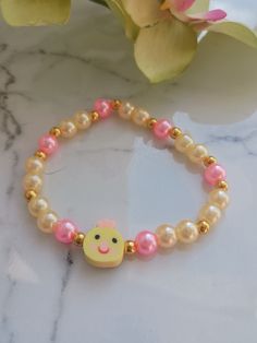 Perfect for Easter or just because! This pale yellow and pink pearl bracelet features the sweetest little chick face. It's sure to bring a smile to your face! These are handmade at the time of order and are made using high-quality stretchy cord and beads. However, they are delicate, and I recommend you do not wear while sleeping, swimming, bathing, or working out.   One size fits most. Standard bracelet size is 7 inches. If you need a custom size, please message me. Please measure your wrist bef Pink Novelty Stretch Bracelet As A Gift, Cute Stretch Bracelet With Round Beads For Gift, Cute Stretch Bracelet With Round Beads As Gift, Pink Novelty Stretch Bracelet As Gift, Pink Novelty Stretch Bracelet For Birthday, Pink Novelty Stretch Bracelet For Gift, Novelty Pink Stretch Bracelet For Birthday, Handmade Novelty Pink Stretch Bracelet, Handmade Pink Novelty Stretch Bracelet