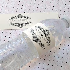 a bottle of water sitting on top of a table next to a card with a name tag