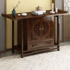 a wooden cabinet sitting in front of a wall with vases on top of it