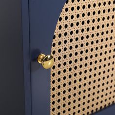 a close up of a metal door with holes on it and a gold knob in the middle