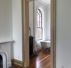 an empty room with a fireplace, mirror and bathtub