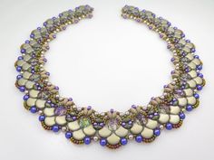 a multi - strand beaded necklace is displayed on a white surface with purple and green beads