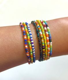 a woman's arm with three different colored bracelets on top of each other