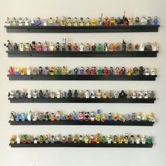 the legos are lined up on the black shelves