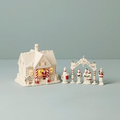 a small white christmas village set up on a blue surface with snowmen and santa's sleigh