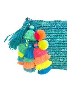 multicolored tasselled bag with pom - poms hanging from it