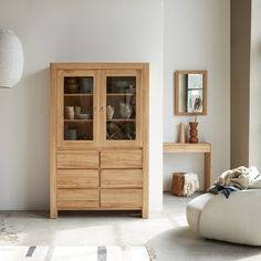 a large wooden cabinet sitting in the middle of a room next to a white couch