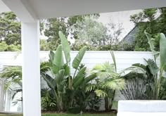 a white couch sitting on top of a green grass covered yard next to a fence