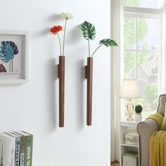 two wooden vases with flowers in them are on the wall next to a bookcase