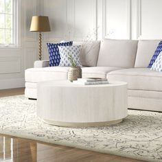 a living room with white furniture and blue pillows