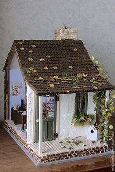 a doll house with flowers on the roof