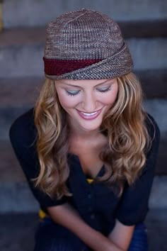 a woman wearing a hat and looking at her cell phone