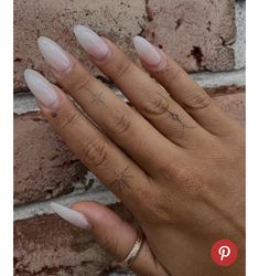 a woman's hand with some white nails on it