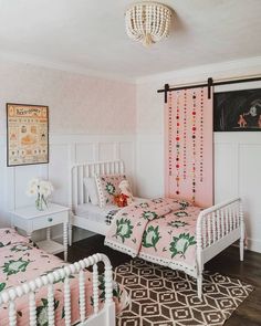 two twin beds in a pink and white bedroom