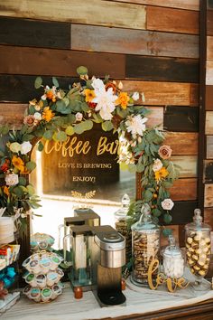 a coffee bar decorated with flowers and greenery