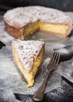 a piece of cake with powdered sugar on top and a fork next to it